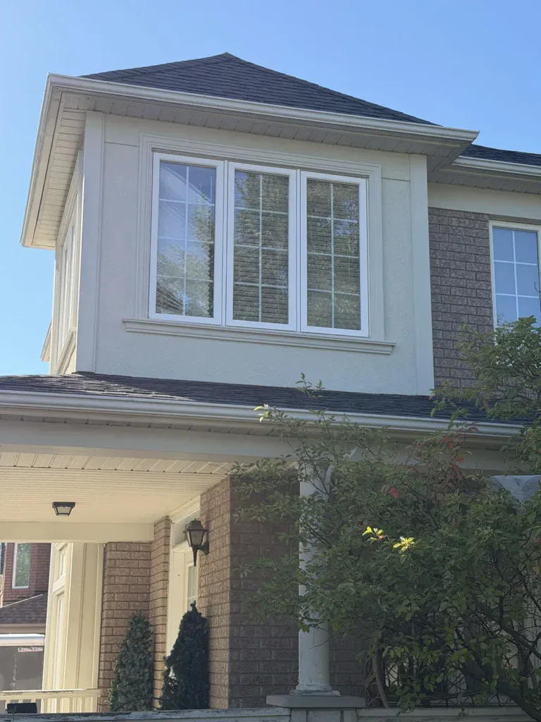Refinished stucco front bay over a covered entrance, seen from below